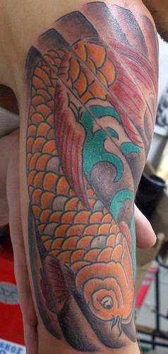 Yellow koi fish in sea tattoo