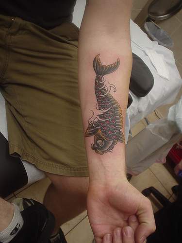 Black koi fish arm tattoo