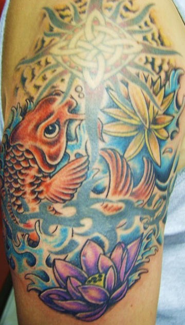 El tatuaje de un pez koi y una flor de loto hecho en color en el brazo o hombro