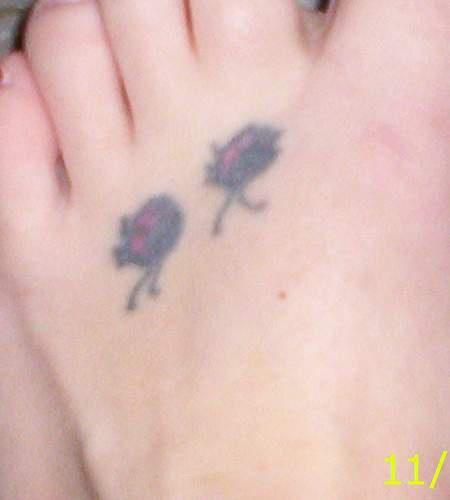 Two small ladybugs  tattoo on foot