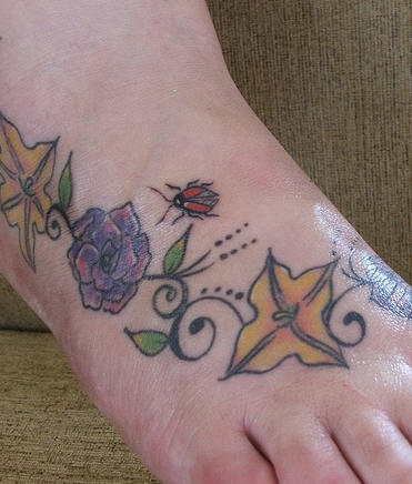 coccinella volante sui fiori tatuaggio