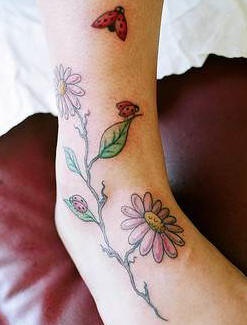 Ladybug on pink daisy coloured tattoo