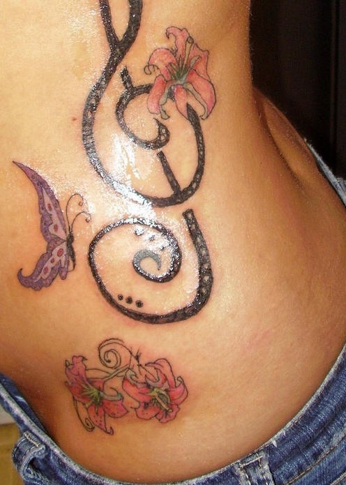 Tatuaje en la cadera, clave de sol grande, mariposa, flores