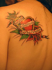 Tatuaje corazón rojo, rosas y una frase en latín