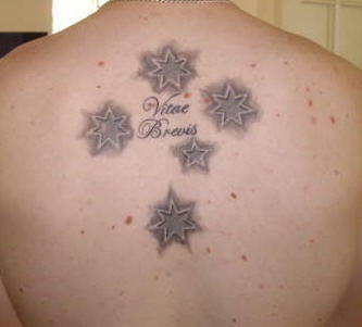Tatuaje de estrellas y la frase vitae brevis