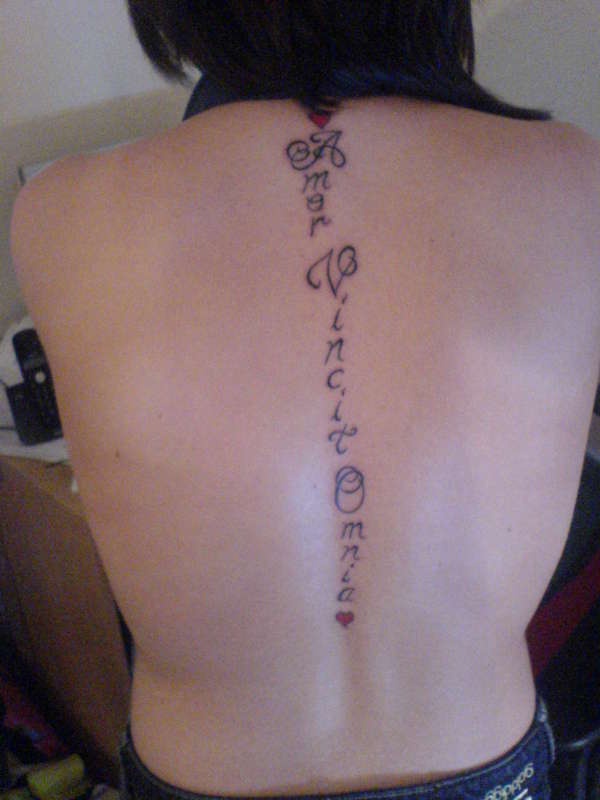 Le tatouage d&quotinscription Amor vincit omnia sur le dos