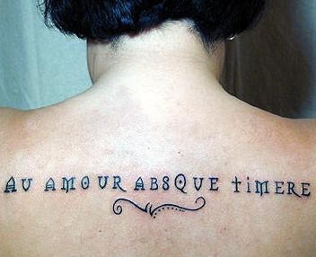 Tatuaje de espalda de una frase en latín