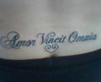 Le tatouage d&quotinscription Amor vincit omnia sur le bas du dos