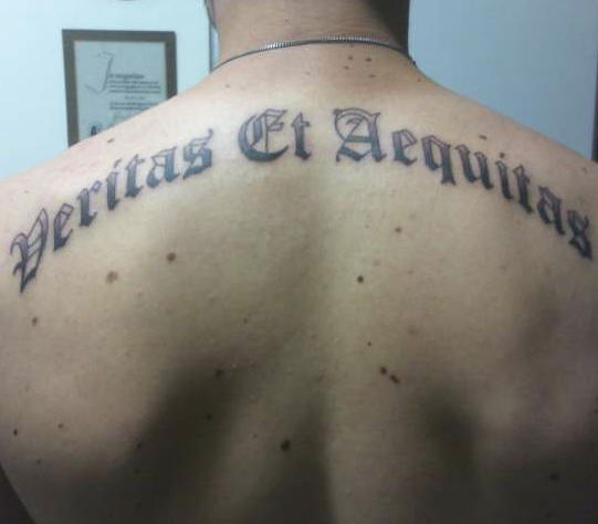Le tatouage d&quotinscription Veritas et aequitas sur le dos