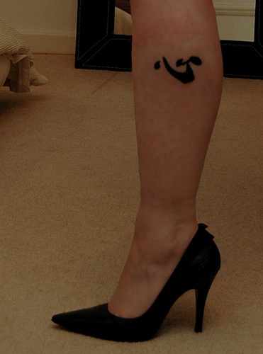 Un hiéroglyphe noir tatouage sur le mollet précis