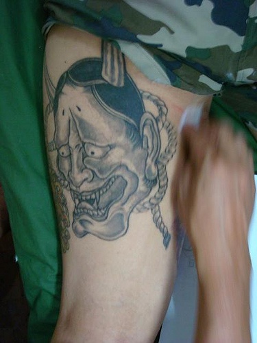 Mostruoso tatuaggio sulla gamba il demone che ride
