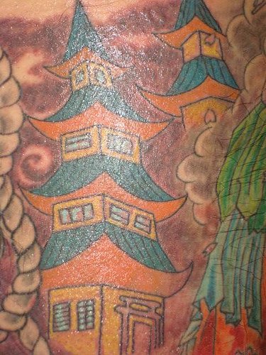 Leg tattoo, colourful tall, designed houses between clouds