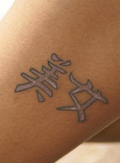 Leg tattoo, light styled hieroglyphs