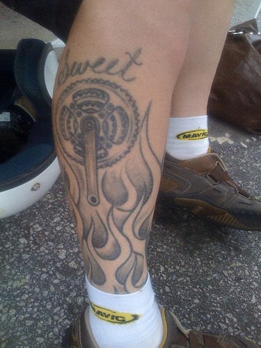 Tatuaggio sulla gamba: l&quotoggetto meccanico, le fiamme e &quotSWEET"