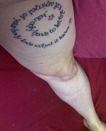 Tatuaje en la pierna, texto escrito en forma de espiral