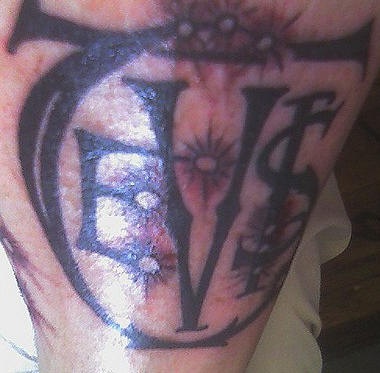 Un signe noir horrible tatouage sur le mollet avec des lettres