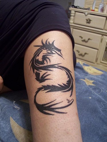 Tatuaje en la pierna, dragon estilizado de color negro