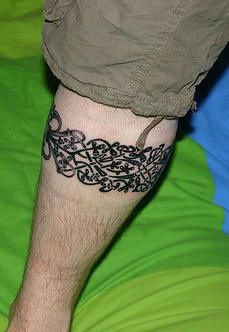 Leg tattoo,black  band of splitted little flowers
