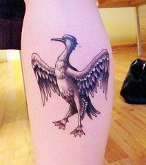 Tatuaje en la pierna, ave con alas desplegadas