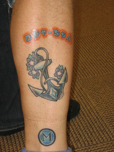 Ancora con i fiori e la scritta tatuati sulla gamba