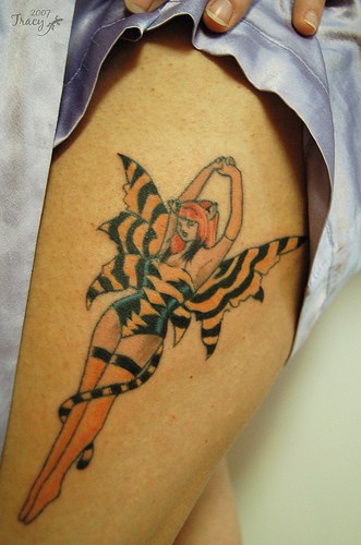 Mince fille dansante en motif tigre tatouage sur le mollet