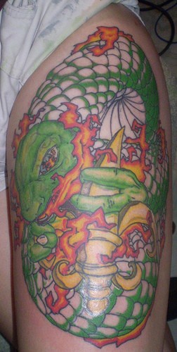 Gros serpent vert tatouage sur le mollet avec une arme en flammes