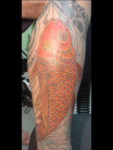 Un gros poisson rouge tatouage sur le mollet pittoresque