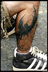 L&quotuccello-dragone colorato tatuato sulla gamba
