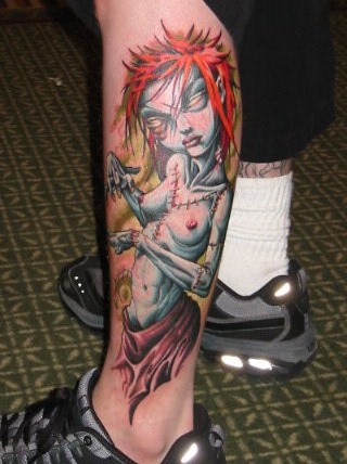 Mostruosa ragazza nuda tatuata sulla gamba
