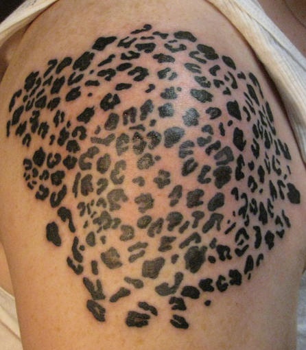 Tatuaggio non colorato sul deltoide il disegno in stile leopardo