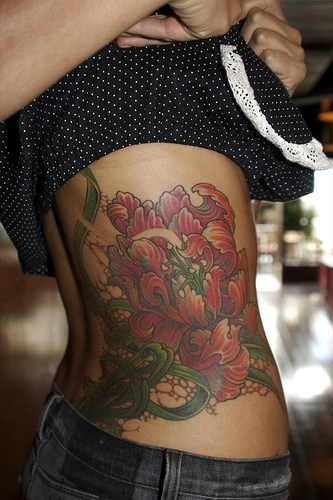 largo tatuaggio di fiori colorati sul lato