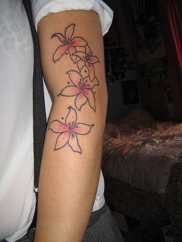 Le tatouage minimaliste de lys roses sur le bras
