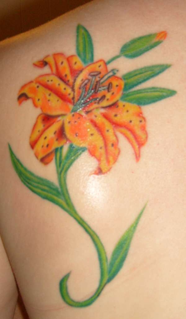 fiore giallo elegante sulla  spalla tatuaggio