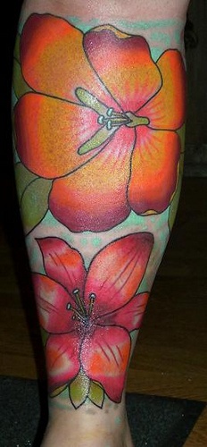 grandi fiori colore arancione sulla gamba tatuaggio