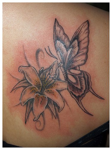 El tatuaje de un Lirio y una mariposa hecho con tinta negra