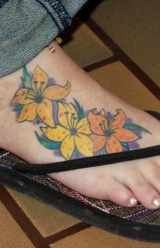 El tatuaje de unos Lirios amarillos hecho en un pie