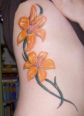 El tatuaje de dos Lirios de color naranja hecho en un costado