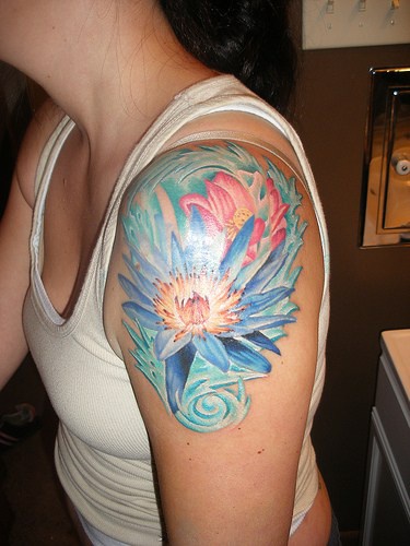 Colourful blue lily tattoo on shoulder