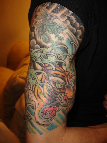 Brüllender Tiger im Wasser Tattoo am Arm