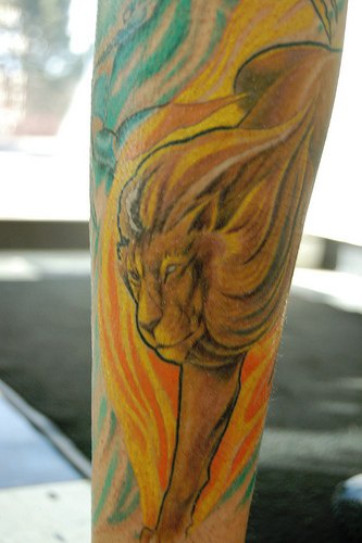 Water coloured lion in fire tattoo
