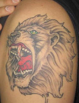Green eyed roaring lion tattoo
