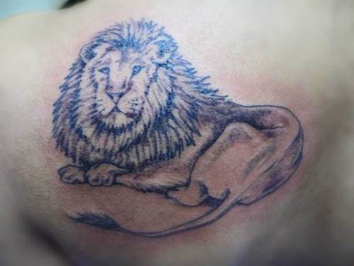 Lying lion black ink tattoo