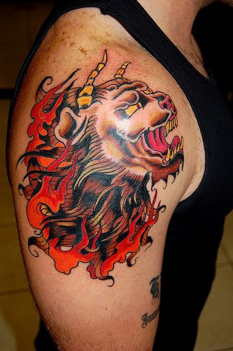 El tatuaje de la cabeza de un leon diablo rugiendo con cuernos hecho al estilo asiatico