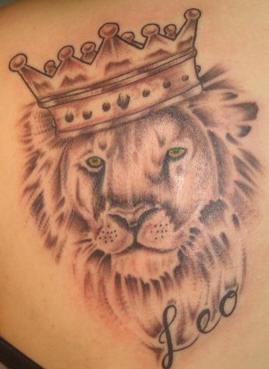 Green eyed lion in crown tattoo