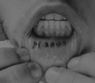 Lip tattoo, manos, black name, near teeth