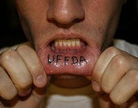 Tattoo mit prägnanter Inschrift &quotUffda" in Schwarz an der Lippe
