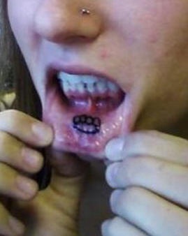 Lip tattoo, black sign like teeth