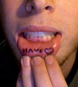 Tatuaje en el labio, palabra have, signo de corazón