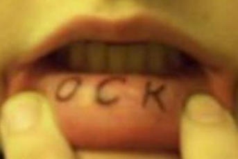 Tatuaggio sul labbro &quotOCK" a lettere grandi