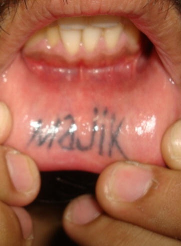 Tatuaje en el labio inferior, majik, letras grandes
